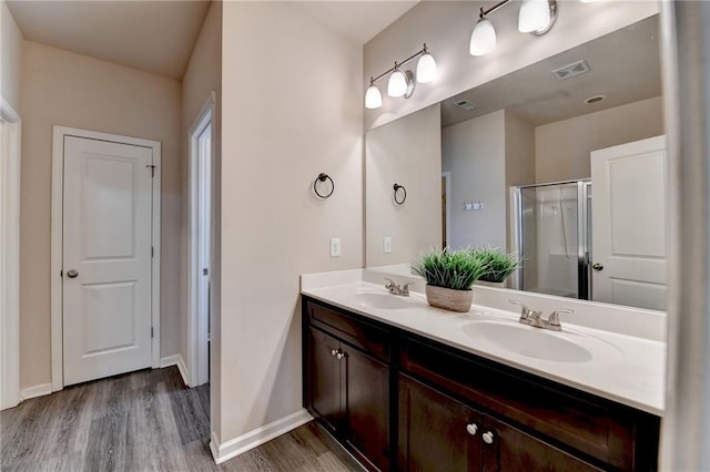 bathroom with a shower with door, vanity, and hardwood / wood-style floors