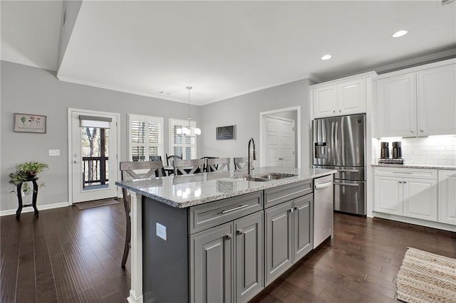 kitchen with a kitchen island with sink, gray cabinets, decorative light fixtures, white cabinetry, and stainless steel appliances