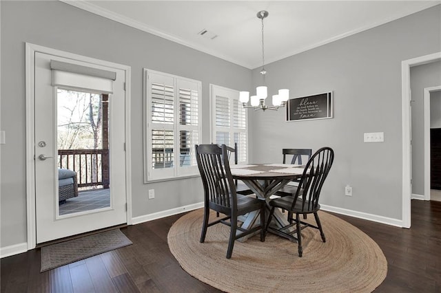 dining space featuring dark hardwood / wood-style floors, crown molding, and a chandelier