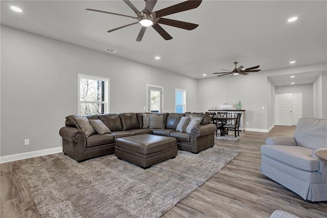 living room featuring light hardwood / wood-style flooring and ceiling fan