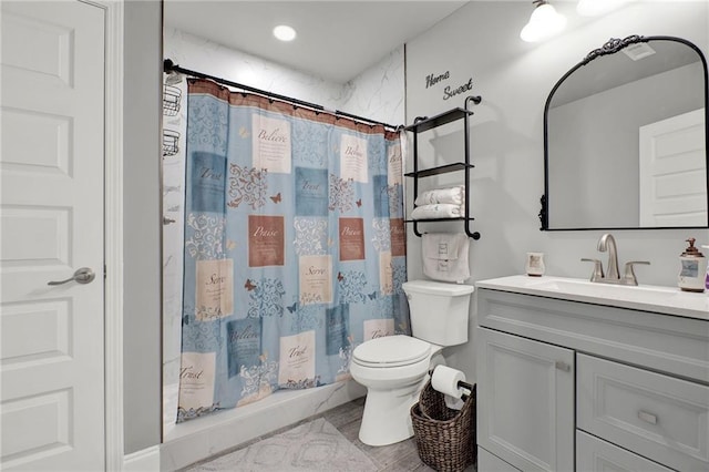 bathroom with a shower with shower curtain, vanity, and toilet