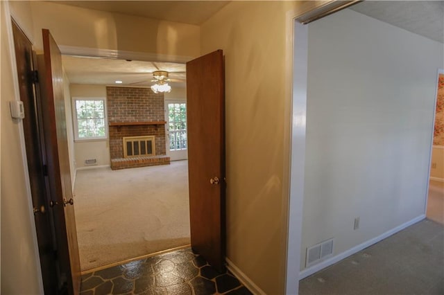 hallway featuring visible vents, baseboards, and carpet flooring