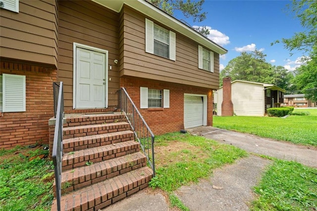 1991 Flat Shoals Rd, Riverdale, GA 30296 - view of exterior entry featuring an attached garage, driveway, brick siding, and a lawn