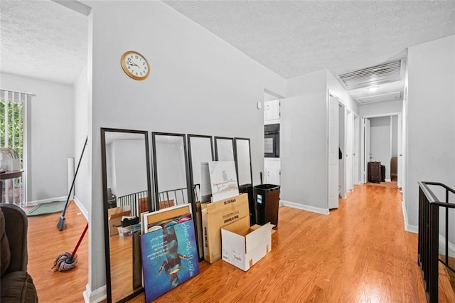 1991 Flat Shoals Rd, Riverdale, GA 30296 - hall with a textured ceiling, light wood finished floors, and lofted ceiling