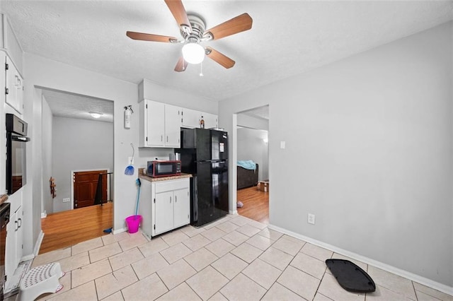 1991 Flat Shoals Rd, Riverdale, GA 30296 - kitchen with black appliances, ceiling fan, white cabinets, light tile patterned flooring, and a textured ceiling