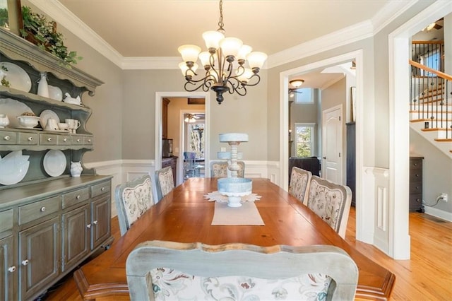 dining area featuring crown molding, an inviting chandelier, and light wood-type flooring