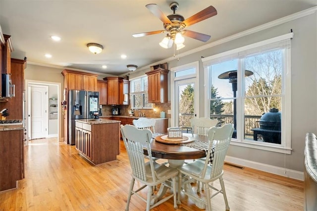 dining area with crown molding, light hardwood / wood-style flooring, and ceiling fan