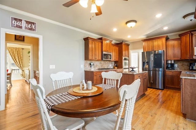 dining space featuring crown molding, ceiling fan, and light wood-type flooring