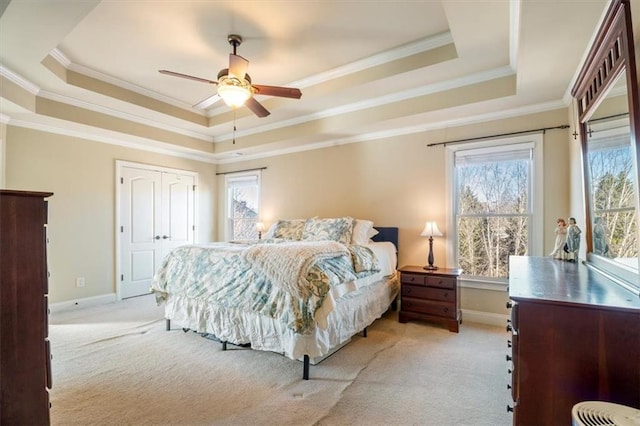 bedroom with ornamental molding, a raised ceiling, and light carpet