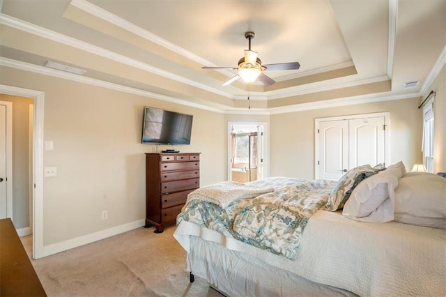 bedroom featuring multiple windows, a tray ceiling, and light carpet