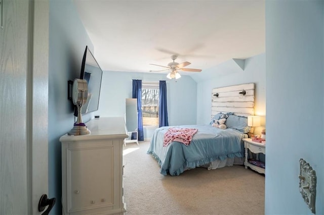 bedroom with vaulted ceiling, light colored carpet, and ceiling fan