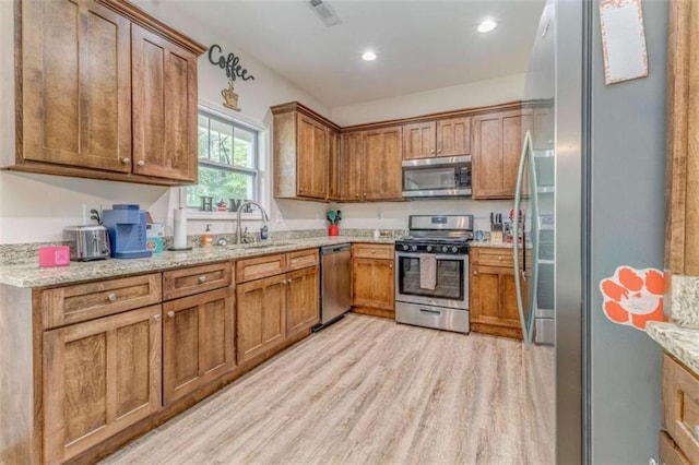 22 Gowen Dr, Rome, GA 30165 - kitchen with appliances with stainless steel finishes, brown cabinetry, light wood-style flooring, a sink, and recessed lighting