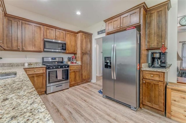 22 Gowen Dr, Rome, GA 30165 - kitchen featuring appliances with stainless steel finishes, light wood-type flooring, brown cabinetry, a sink, and recessed lighting