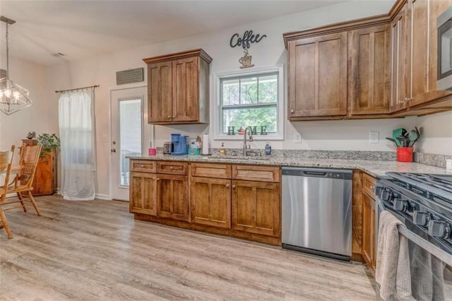 22 Gowen Dr, Rome, GA 30165 - kitchen with stainless steel appliances, a chandelier, brown cabinets, and light wood-style flooring
