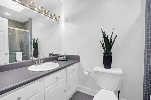 bathroom with a skylight, tile patterned floors, an enclosed shower, toilet, and vanity