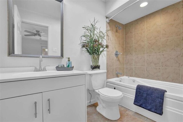 full bathroom with ceiling fan, tiled shower / bath combo, tile patterned floors, toilet, and vanity