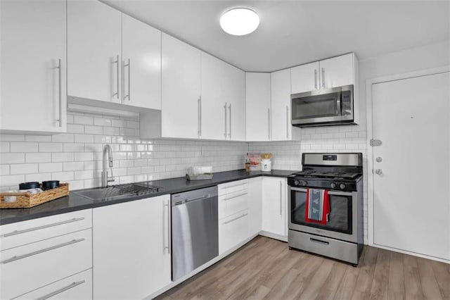 kitchen with sink, white cabinetry, and stainless steel appliances