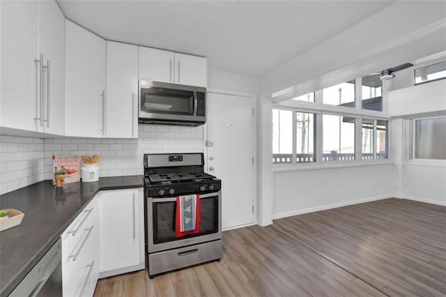 kitchen with white cabinets, stainless steel appliances, light hardwood / wood-style flooring, and tasteful backsplash