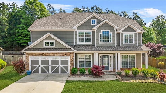 2625 Blackstock Dr, Cumming, GA 30041 - craftsman house featuring fence, an attached garage, driveway, stone siding, and a front yard