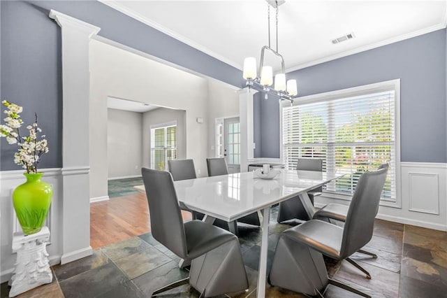 2625 Blackstock Dr, Cumming, GA 30041 - dining space with a wainscoted wall, visible vents, a notable chandelier, stone finish flooring, and crown molding