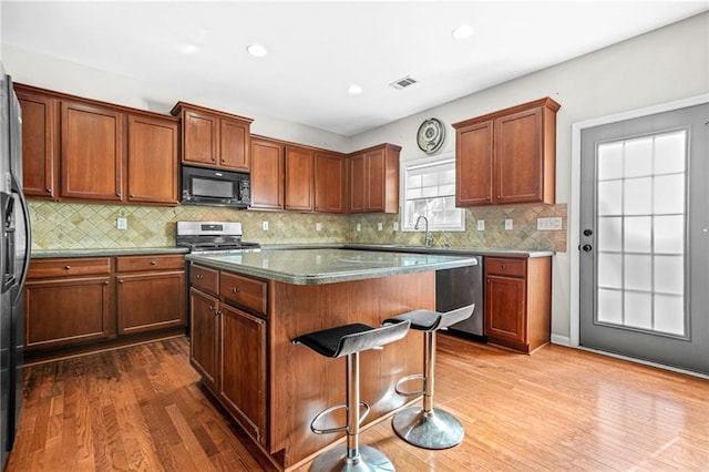 2625 Blackstock Dr, Cumming, GA 30041 - kitchen featuring stainless steel appliances, a center island, a sink, visible vents, and dark wood-type flooring
