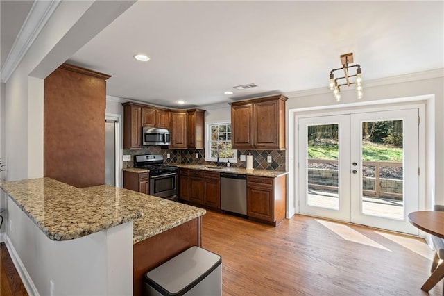 260 Mansell Cir, Roswell, GA 30075 - kitchen with a sink, stainless steel appliances, french doors, a peninsula, and crown molding