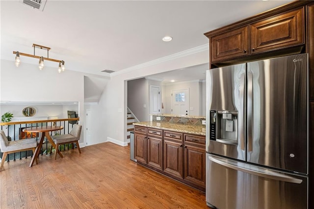 260 Mansell Cir, Roswell, GA 30075 - kitchen with visible vents, light wood-style flooring, ornamental molding, stainless steel fridge, and baseboards