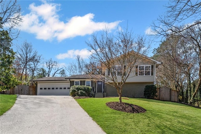 split level home with brick siding, fence, aphalt driveway, a front yard, and a garage