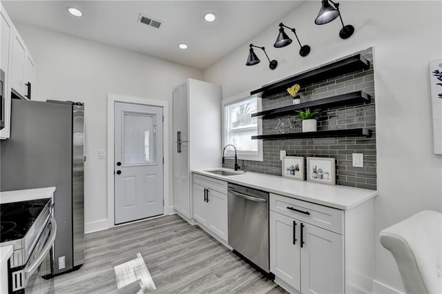 543 Paines Ave NW, Atlanta, GA 30318 - kitchen featuring appliances with stainless steel finishes, white cabinets, and a sink