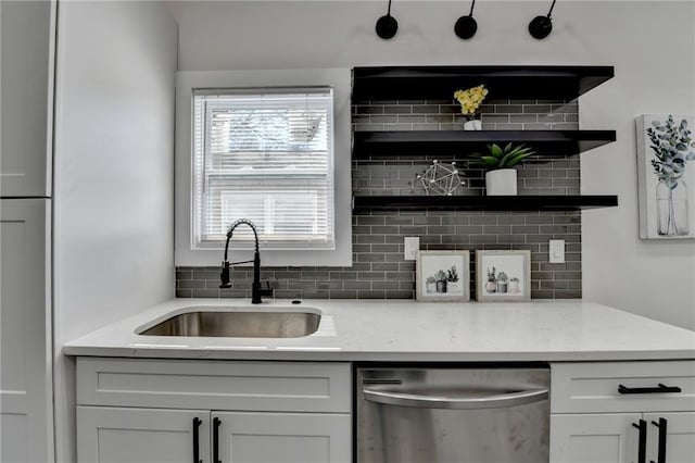 543 Paines Ave NW, Atlanta, GA 30318 - kitchen with backsplash, stainless steel dishwasher, white cabinets, a sink, and light stone countertops
