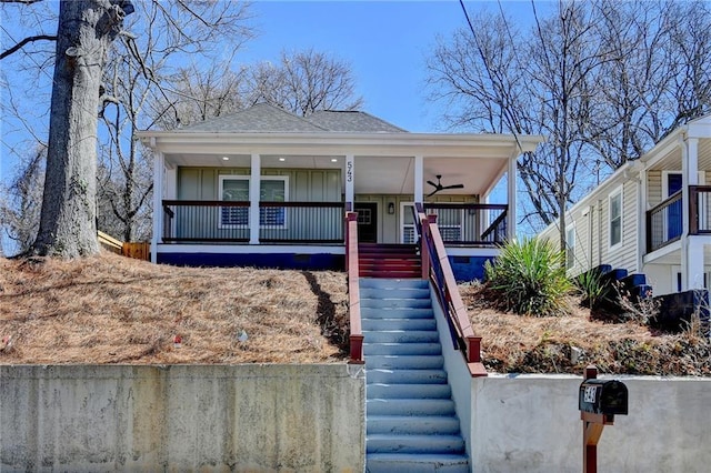 view of front of home with a ceiling fan, roof with shingles, stairs, a porch, and board and batten siding