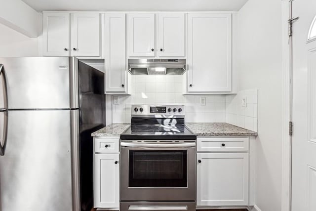 kitchen featuring stainless steel appliances, light stone countertops, white cabinets, and decorative backsplash