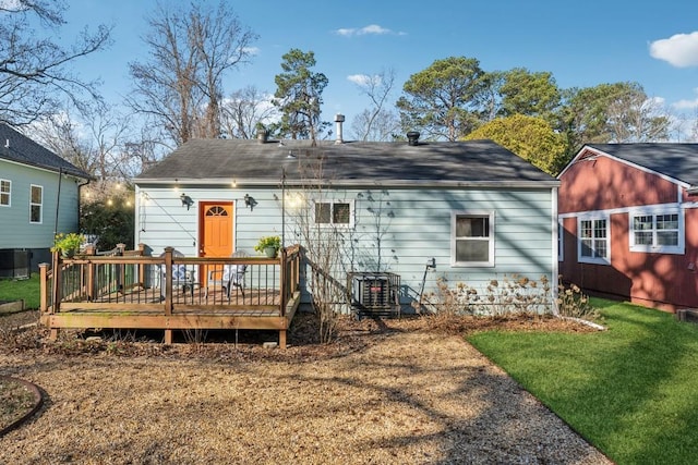 back of property with a lawn, central air condition unit, and a deck