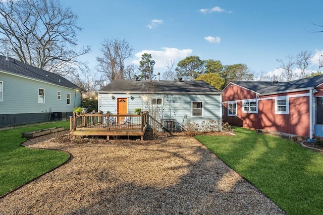 rear view of property featuring central AC unit, a yard, and a deck