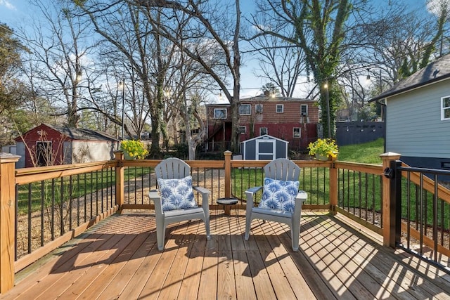 wooden deck with a storage unit and a lawn