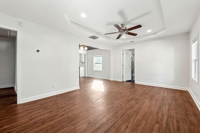 spare room featuring ceiling fan, dark hardwood / wood-style flooring, and a raised ceiling