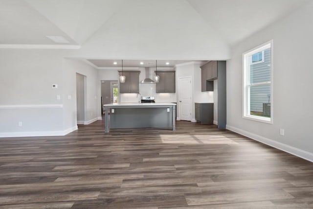 kitchen with dark hardwood / wood-style floors, pendant lighting, a kitchen island, and wall chimney exhaust hood