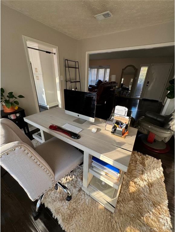 office area with a textured ceiling and dark hardwood / wood-style floors