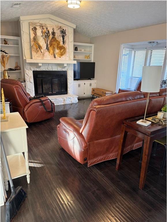 living room with a textured ceiling, dark hardwood / wood-style floors, lofted ceiling, and a fireplace