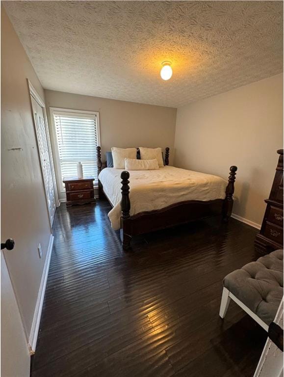 bedroom with a textured ceiling and dark hardwood / wood-style flooring