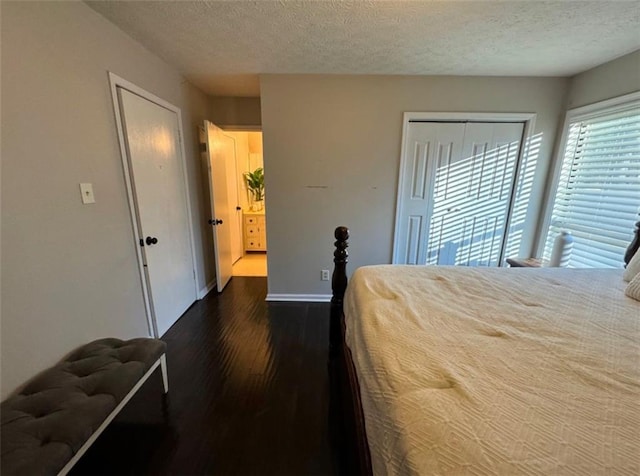 bedroom featuring a closet, dark wood-type flooring, and a textured ceiling