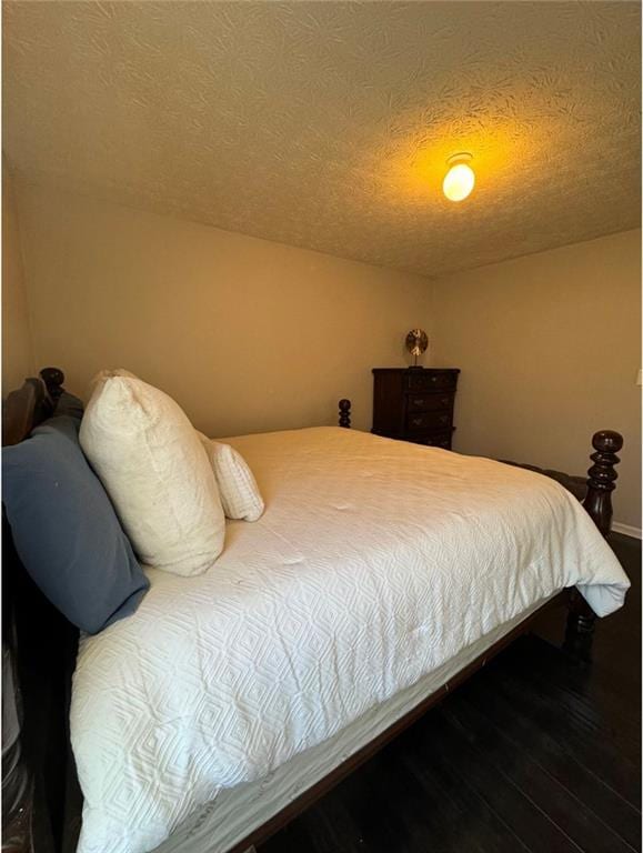 bedroom with a textured ceiling and hardwood / wood-style floors