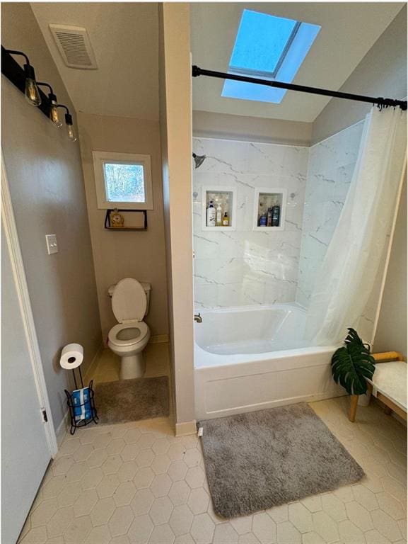 bathroom with tile patterned flooring, toilet, a skylight, and shower / bath combination with curtain