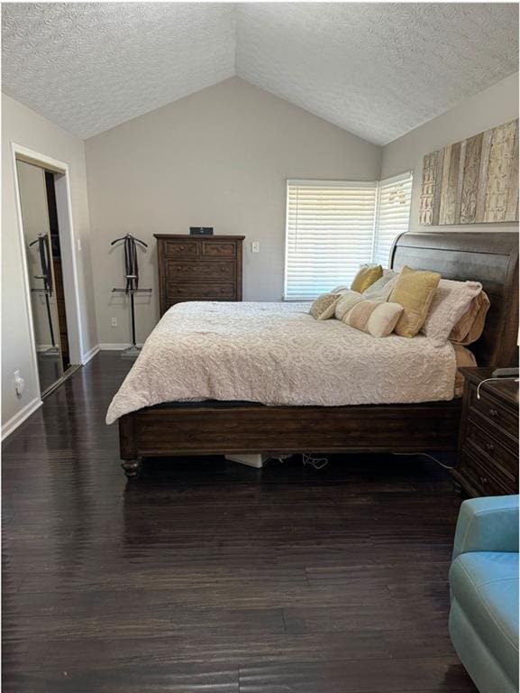 bedroom with a textured ceiling, dark hardwood / wood-style flooring, and lofted ceiling