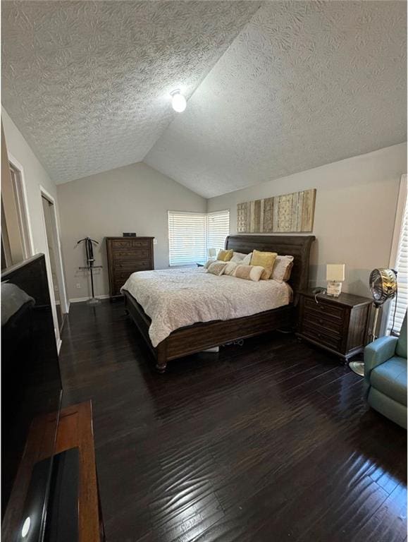 bedroom with vaulted ceiling, a textured ceiling, and dark hardwood / wood-style flooring