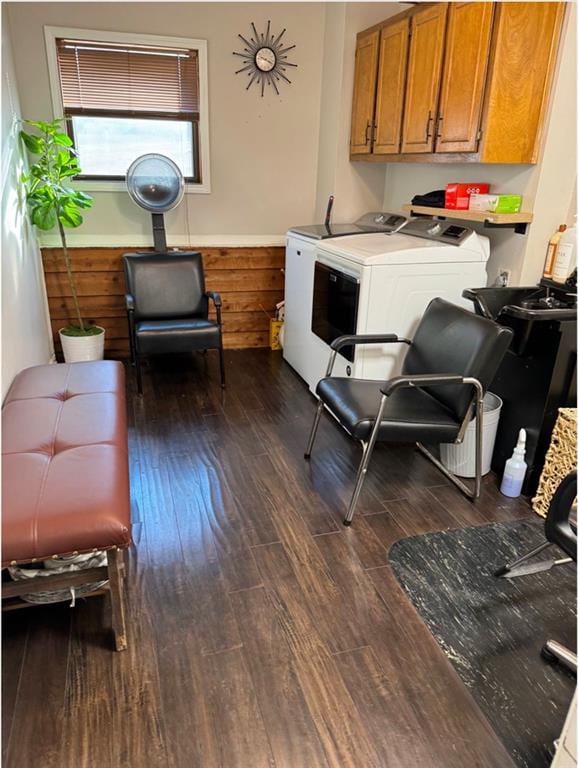 laundry room featuring washing machine and clothes dryer, dark wood-type flooring, and cabinets