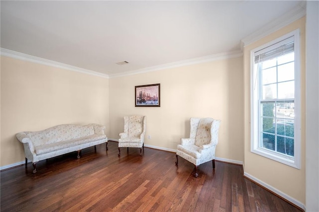 sitting room with baseboards, wood finished floors, visible vents, and crown molding