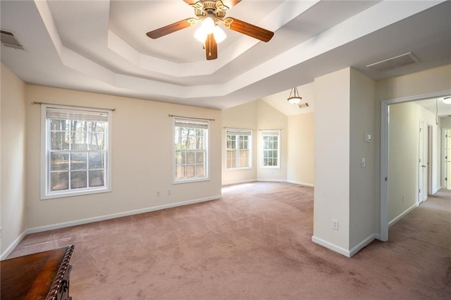 unfurnished room with visible vents, baseboards, a ceiling fan, carpet, and a tray ceiling