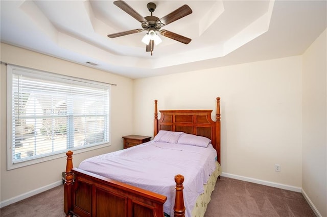 bedroom with visible vents, a raised ceiling, light colored carpet, and baseboards