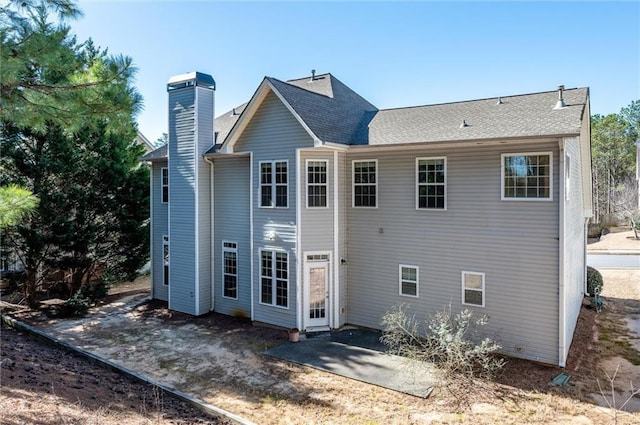 back of property featuring a patio area and a chimney